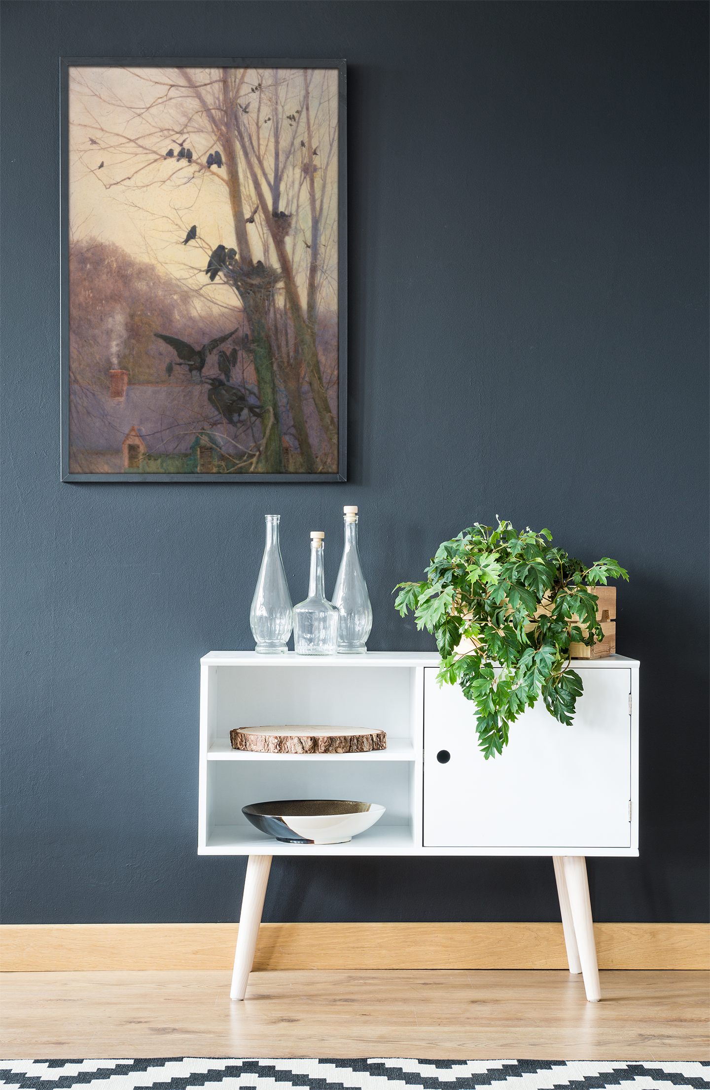 White cabinet with decorative items against a dark wall with a framed Irish art print.