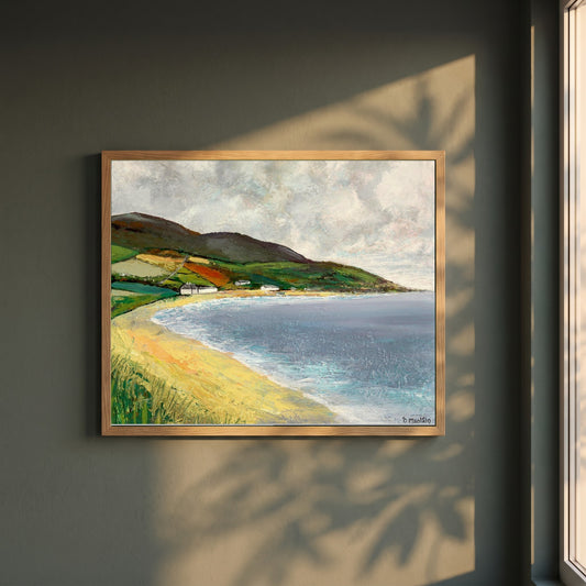 Cushendun Beach, County Antrim framed print in a natural oak frame on a dark green wall beside a window, dappled plant shadow