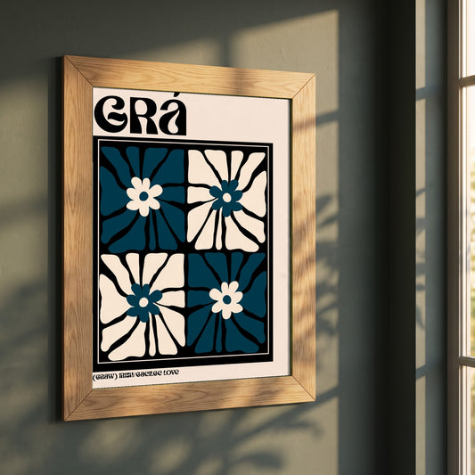 Grá framed print in a natural oak frame on a dark green wall beside a window, dappled plant shadow