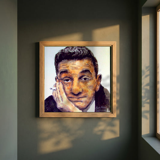 John B. Keane framed print in a natural oak frame on a dark green wall beside a window, dappled plant shadow