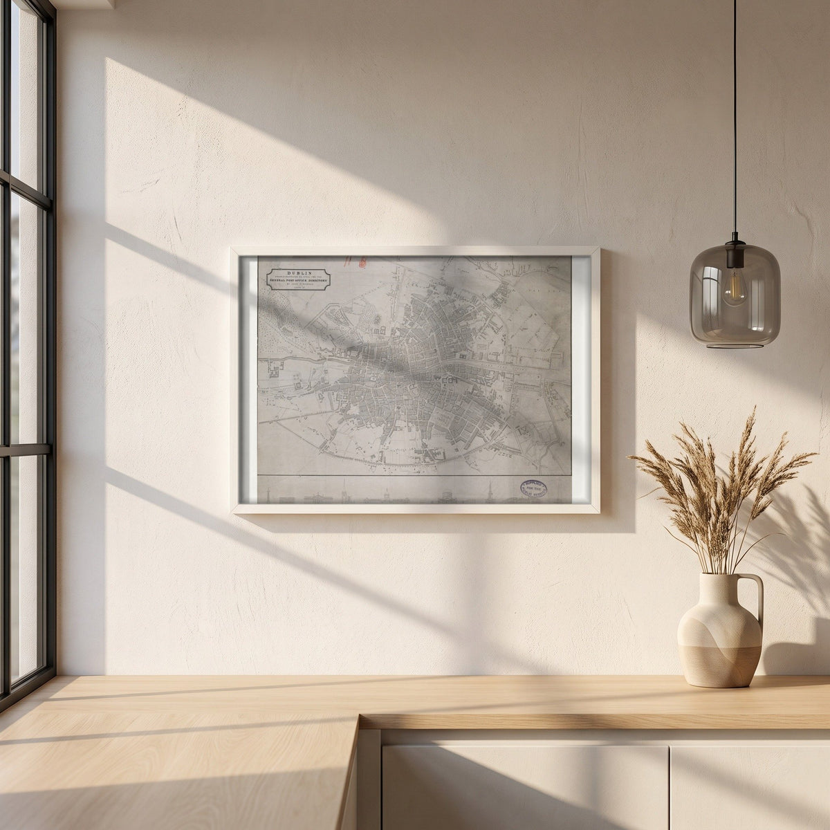 1830 Dublin Map by John Kirkwood framed print in a white frame on a plaster wall above an oak worktop in a bright Scandinavian kitchen