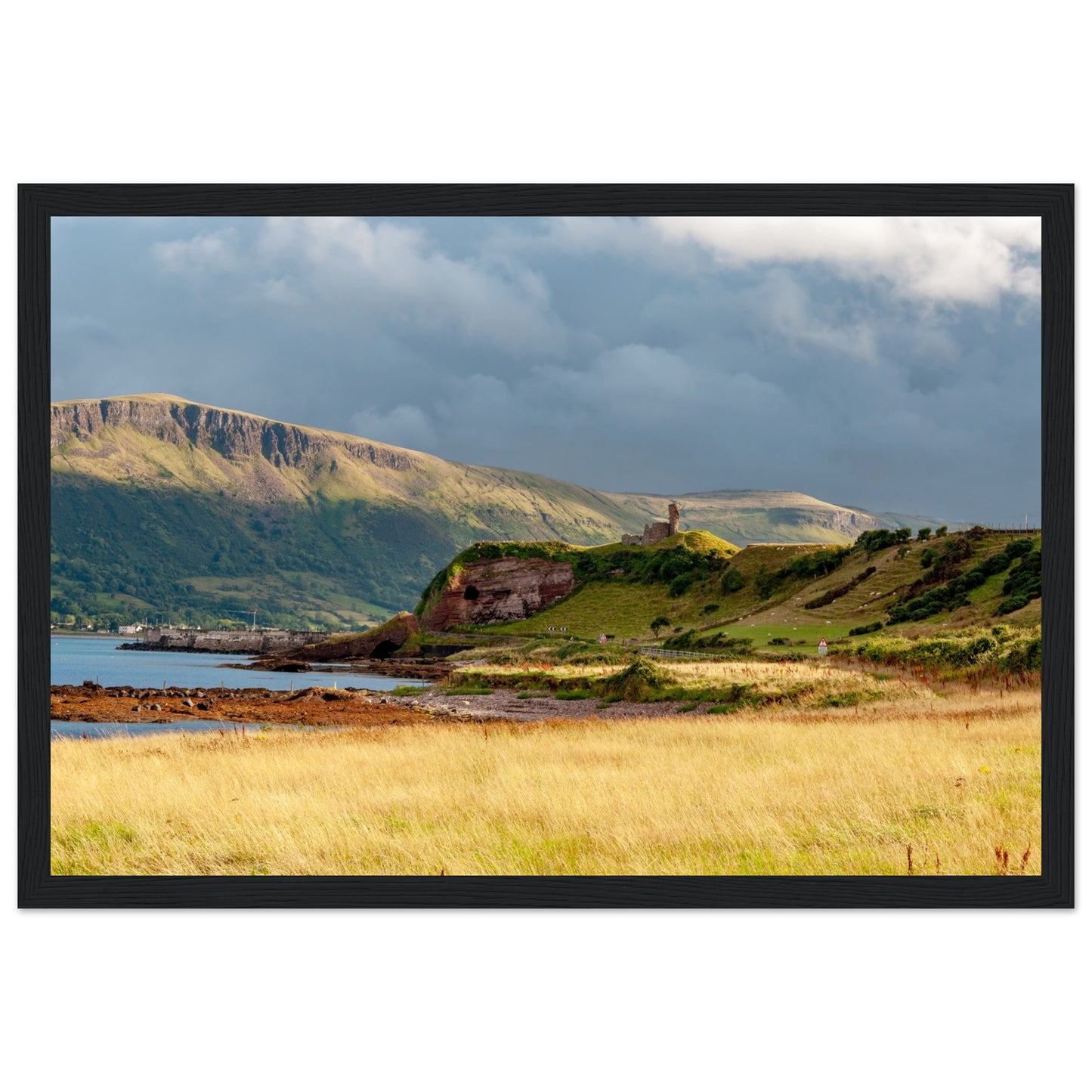 A framed print featuring Red Bay Castle amidst coastal cliffs, capturing the rugged beauty of County Antrim's Causeway Coastal Route. Historical charm meets natural grandeur in this stunning artwork.