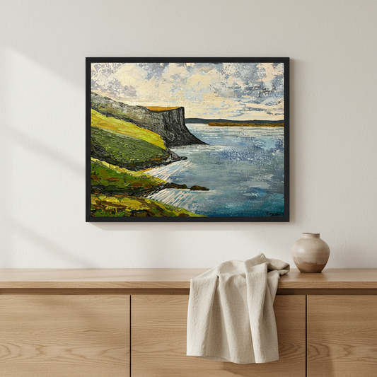 Murlough Bay and Fair Head, County Antrim – original Irish landscape painting by Barra Ó Maoláin in black wood frame above oak sideboard