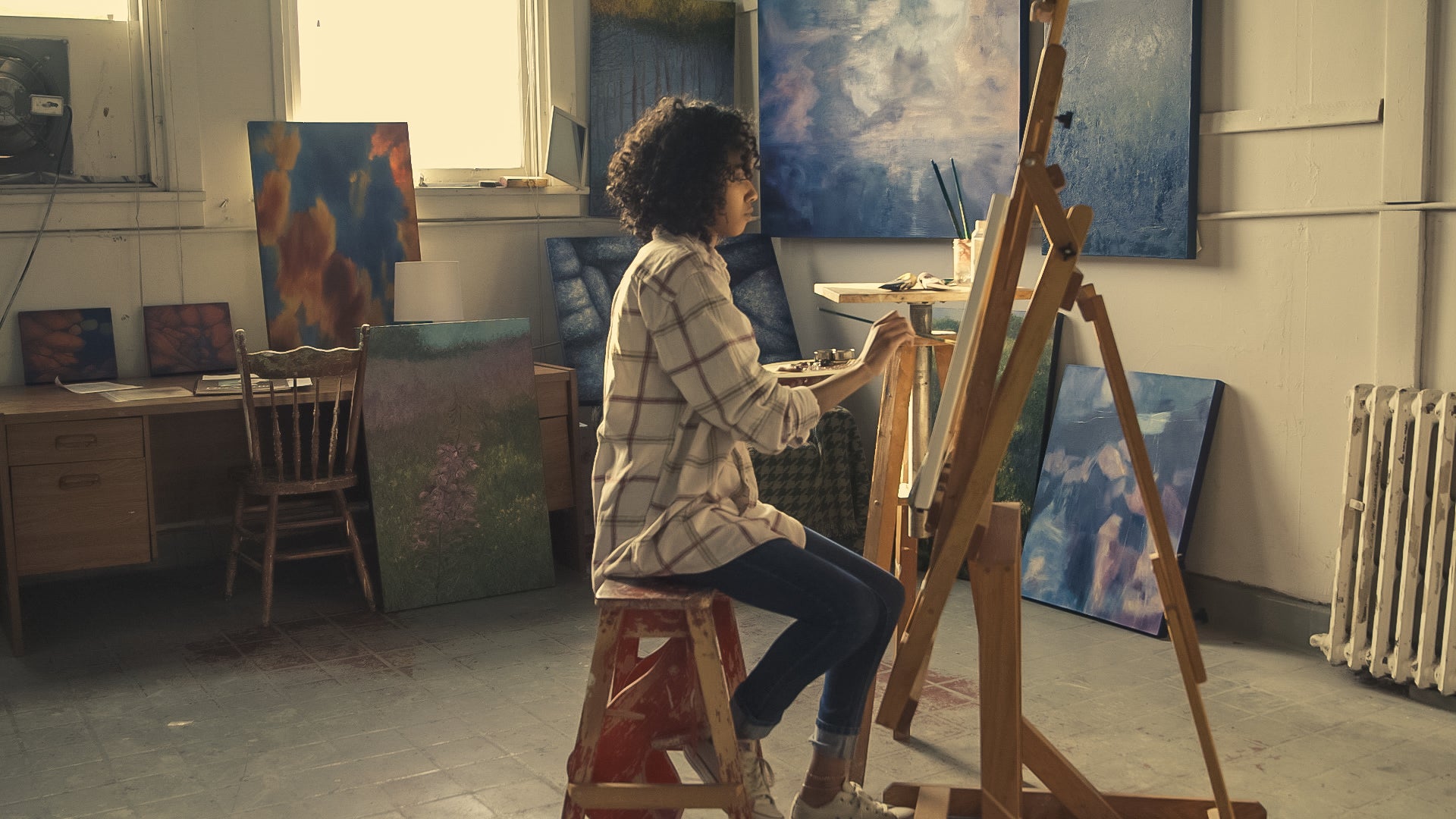 Female Irish Artist working on an original painting in her rented art studio Belfast Buy-Irish-Art.ie