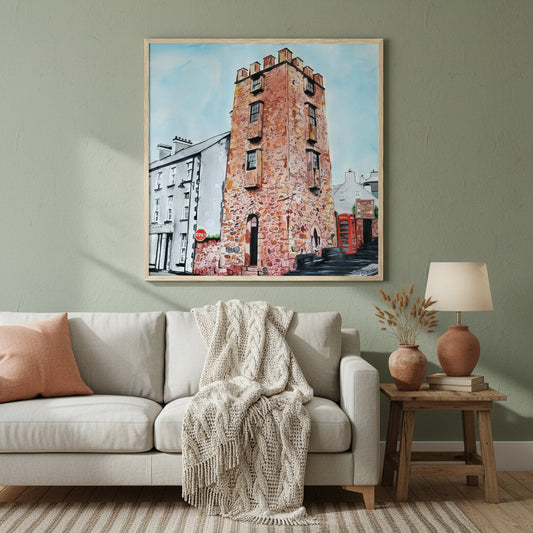 Large 70×70 cm natural oak-framed art print of The Curfew Tower Cushendall displayed in a warm Irish-inspired home interior, muted earthy palette, soft lamplight ambience, premium lifestyle photography highlighting frame texture and artwork detail.”Framed art print 'The Curfew Tower' by Ó Maoláin. This piece depicts The Curfew Tower in Cushendall, Glens of Antrim, built by Francis Turnley in 1820 and now owned by Bill Drummond. The artwork showcases the tower amid the scenic Glens of Antrim.
