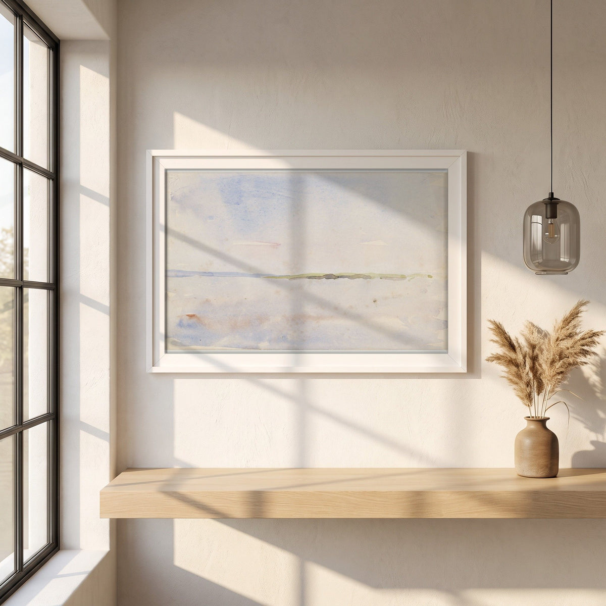 A Distant Coastline framed print in a white frame on a plaster wall above an oak worktop in a bright Scandinavian kitchen