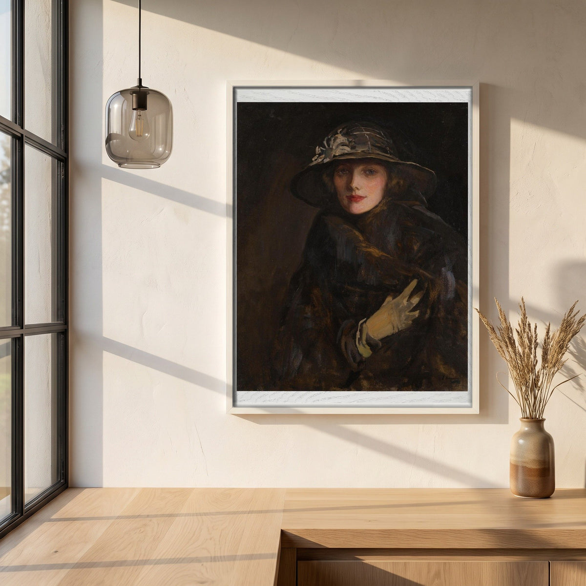 A Lady in Brown (1920) framed print in a white frame on a plaster wall above an oak worktop in a bright Scandinavian kitchen