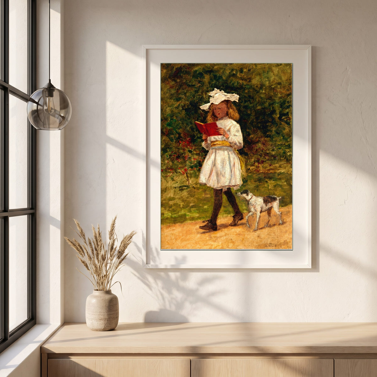 A Young Girl Reading framed print in a white frame on a plaster wall above an oak worktop in a bright Scandinavian kitchen
