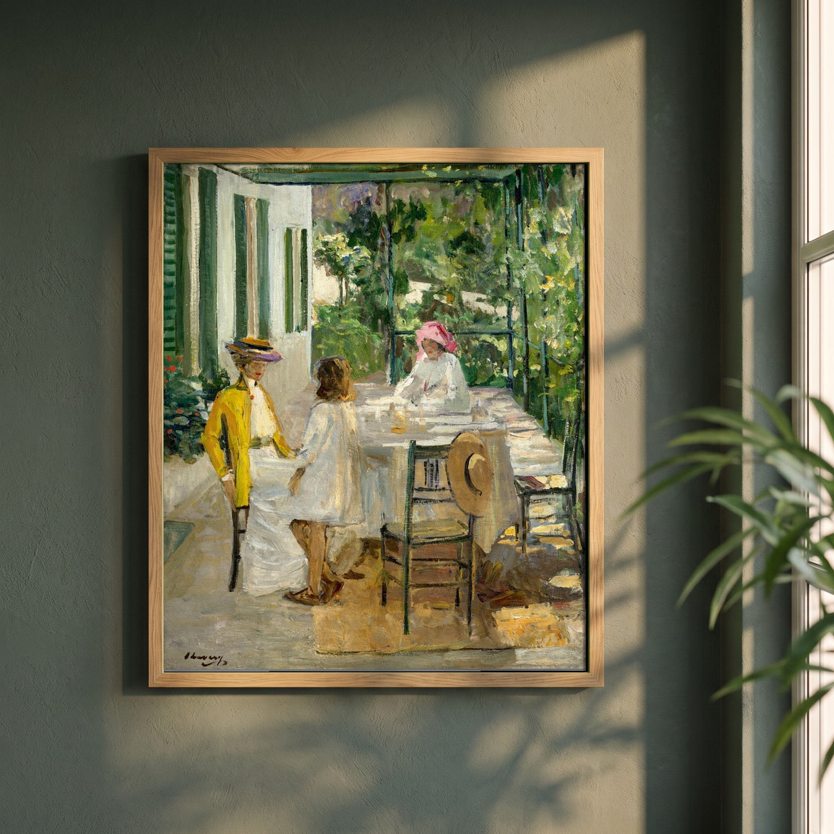 After Breakfast, Tangier framed print in a natural oak frame on a dark green wall beside a window, dappled plant shadow