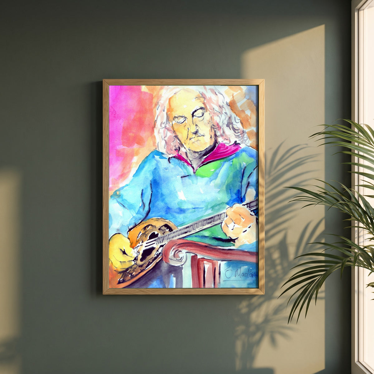 Alec Finn Bouzouki De Dannan framed print in a natural oak frame on a dark green wall beside a window, dappled plant shadow