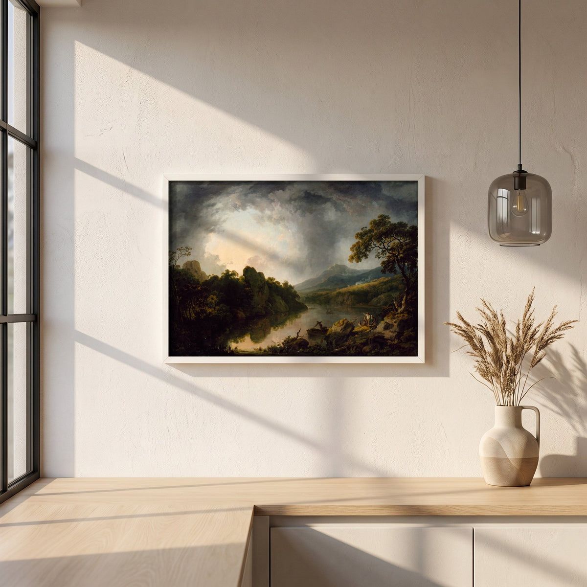 An Extensive Wooded River Landscape with Fishermen framed print in a white frame on a plaster wall above an oak worktop in a bright Scandinavian kitchen