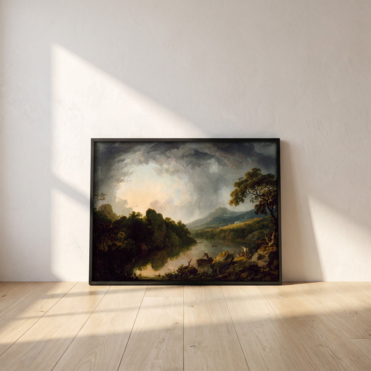 An Extensive Wooded River Landscape with Fishermen framed print in a black frame leaning against a white plaster wall on oak floorboards in morning light
