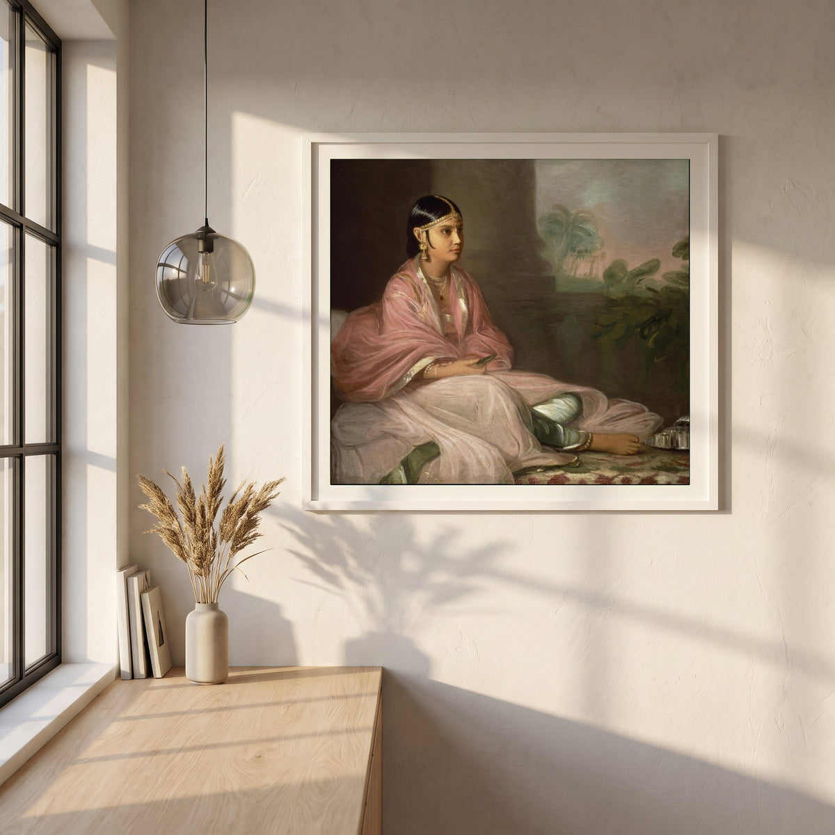 An Indian Lady framed print in a white frame on a plaster wall above an oak worktop in a bright Scandinavian kitchen