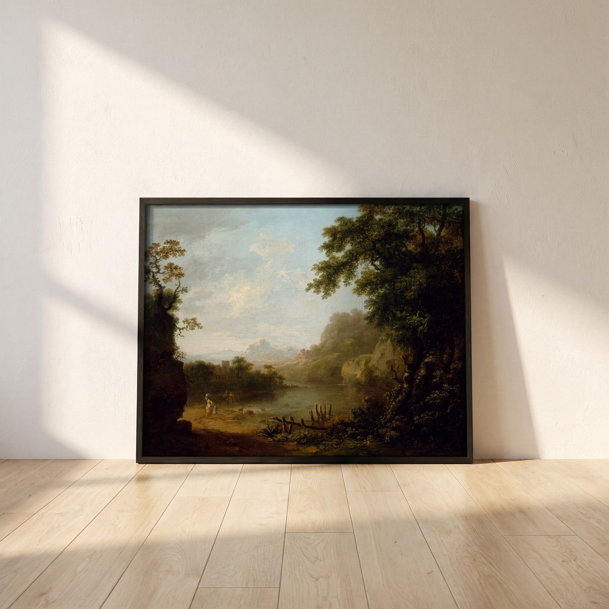 An Italianate Wooded River Landscape with Figures framed print in a black frame leaning against a white plaster wall on oak floorboards in morning light