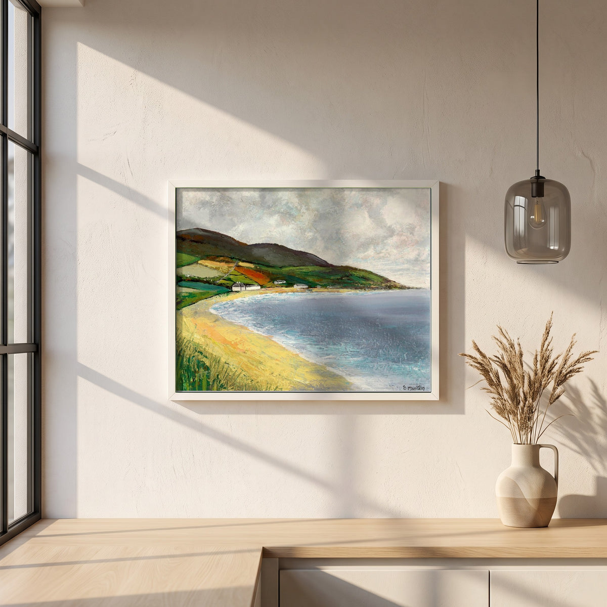 Cushendun Beach, County Antrim framed print in a white frame on a plaster wall above an oak worktop in a bright Scandinavian kitchen