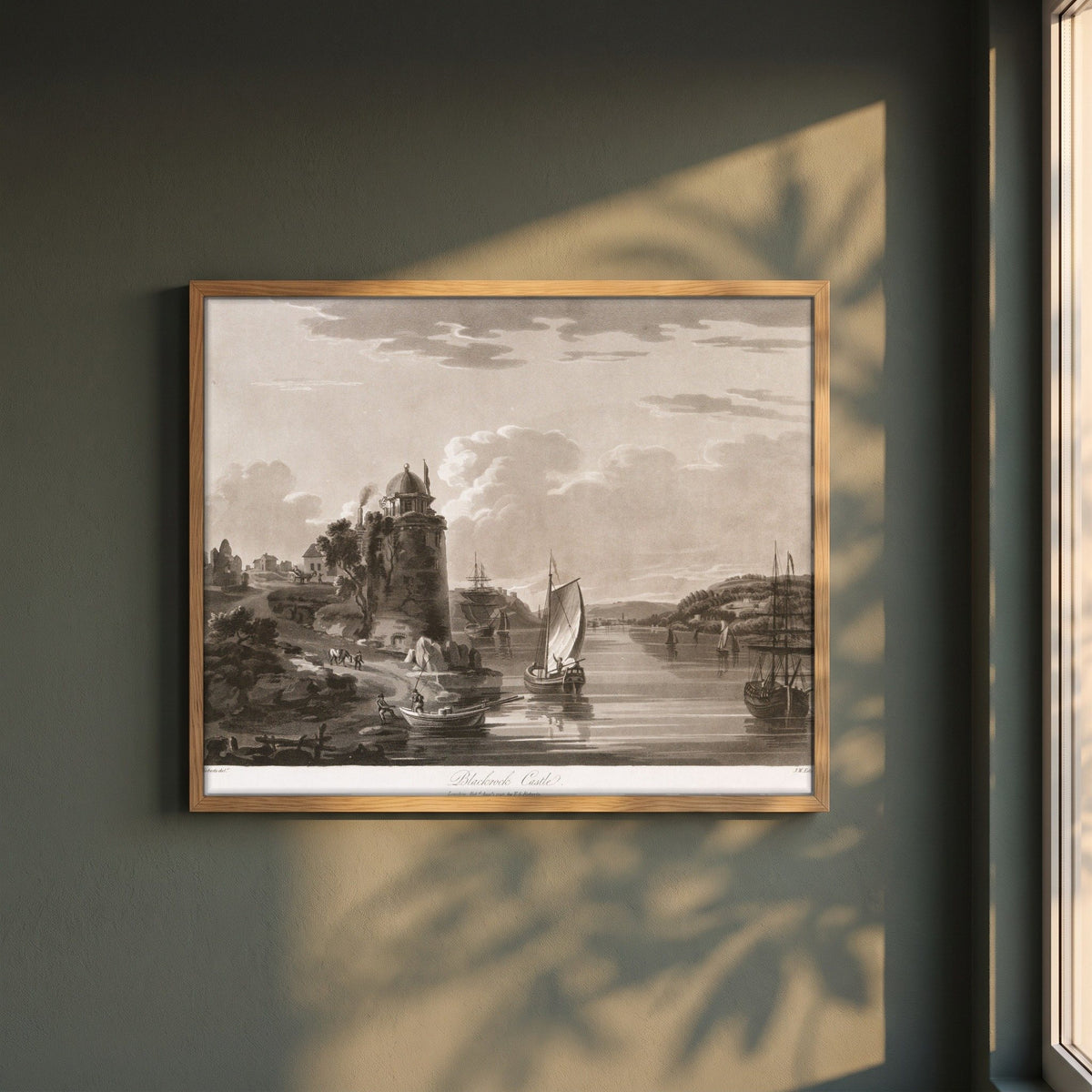 Blackrock Castle 1796 by Thomas Sautelle Roberts Art Print framed print in a natural oak frame on a dark green wall beside a window, dappled plant shadow