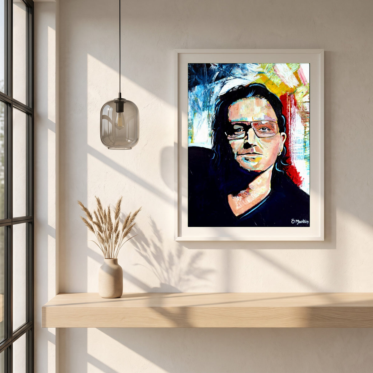 Vibrant Bono U2 framed print in a white frame on a plaster wall above an oak worktop in a bright Scandinavian kitchen