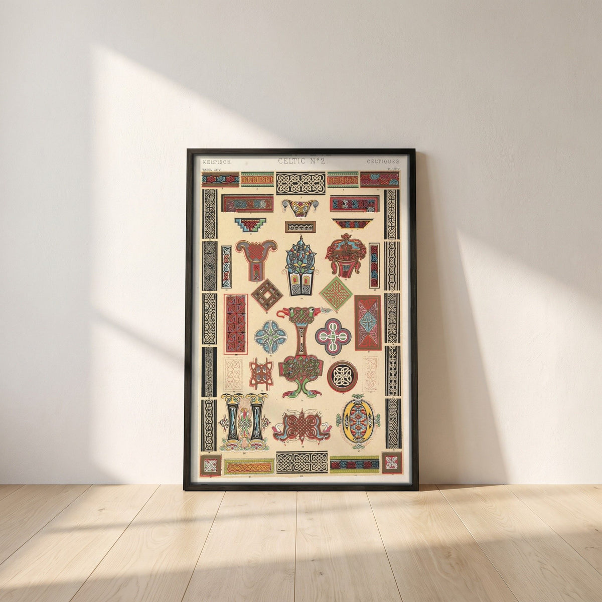 Celtic No.2 by Owen Jones framed print in a black frame leaning against a white plaster wall on oak floorboards in morning light