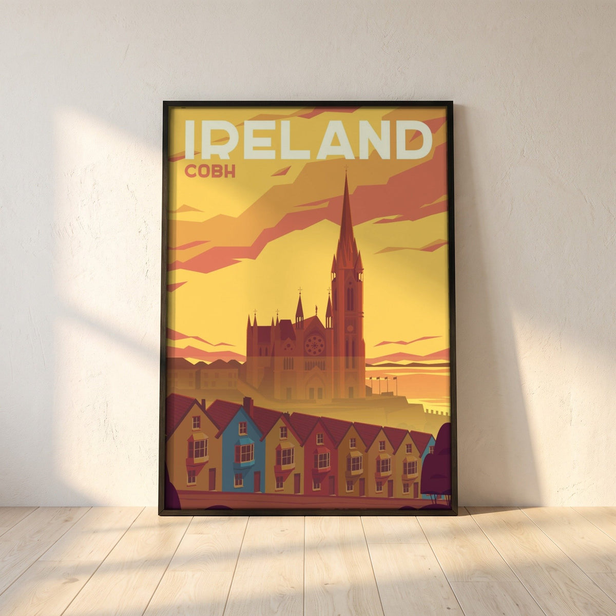 Cobh, Cork retro travel poster in a black frame leaning against a white plaster wall on oak floorboards in morning light
