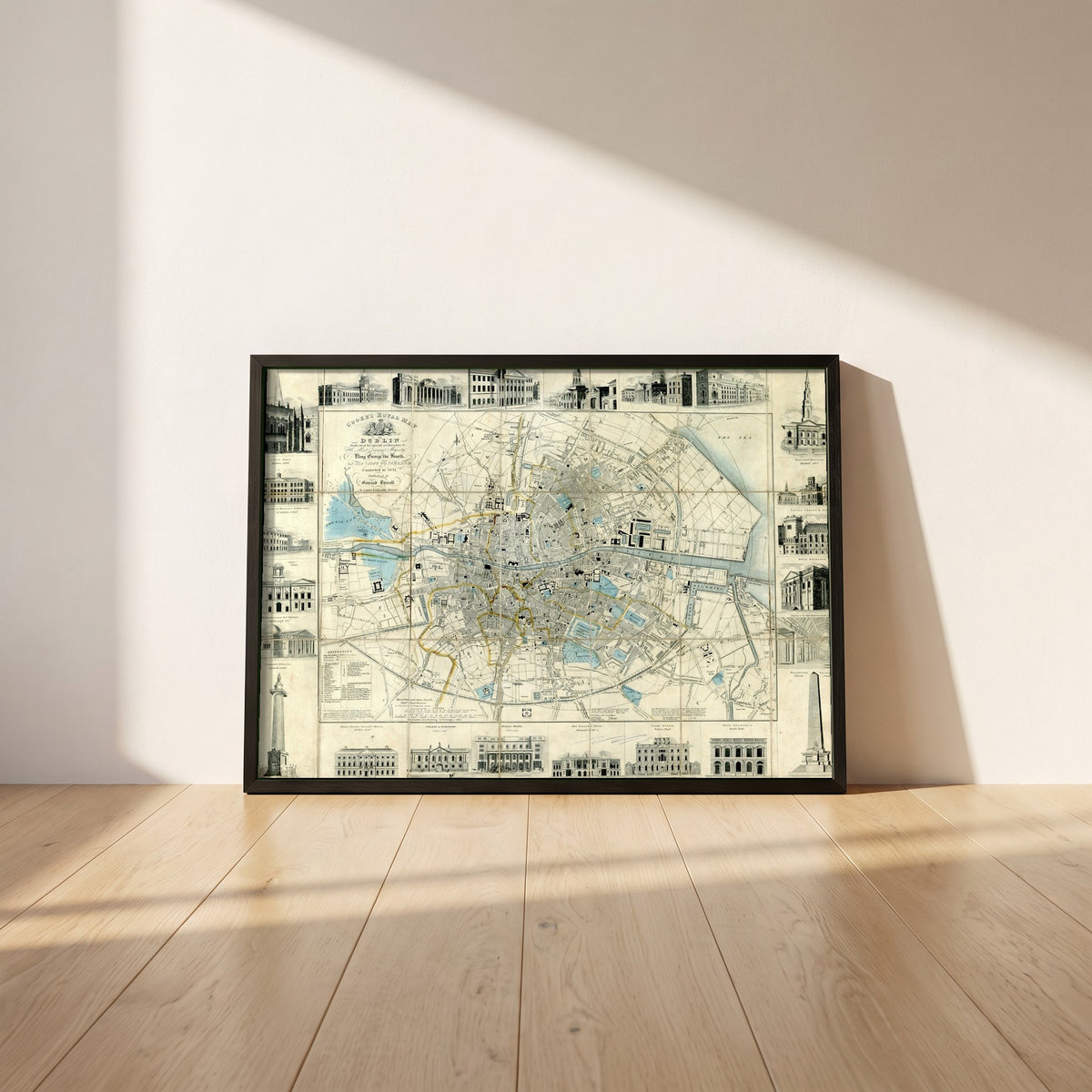 Cooke's Royal Map of Dublin framed print in a black frame leaning against a white plaster wall on oak floorboards in morning light