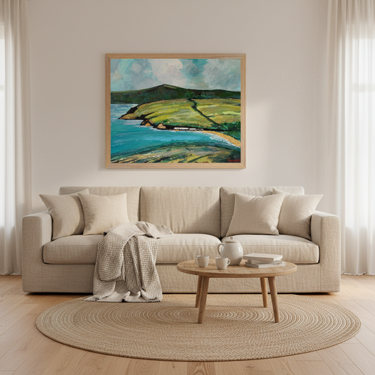 Cushendun Landscape by Ó Maoláin framed Irish art print above a linen sofa in a warm living room