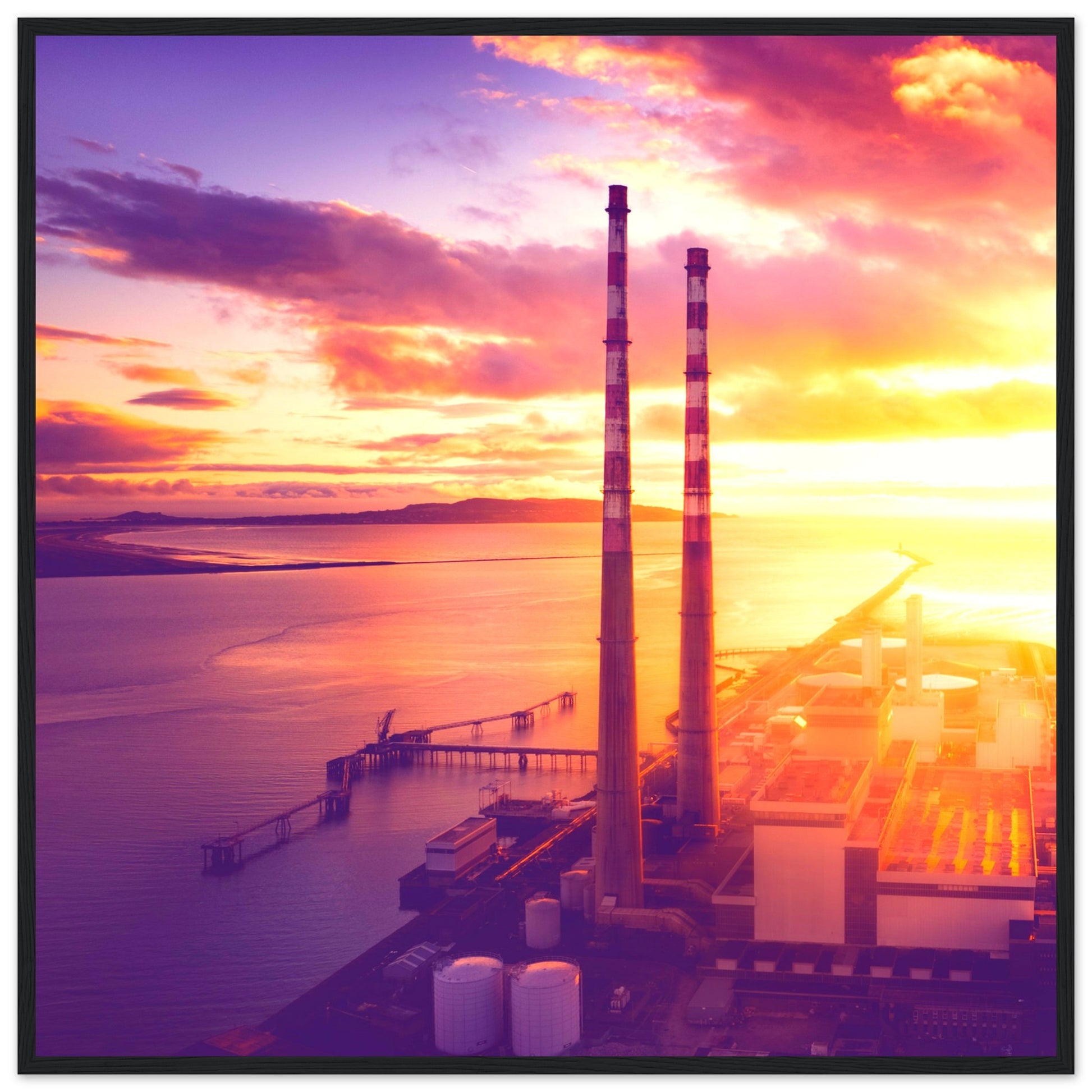 A framed print of Dublin's industrial landscape, featuring the iconic Poolbeg Towers and Lighthouse at sunrise. This aerial view captures the blend of industrial structures with a serene, sunlit horizon, showcasing the harmony between technology and nature. Perfect for admirers of drone photography, industrial architecture, and Ireland's coastal beauty.