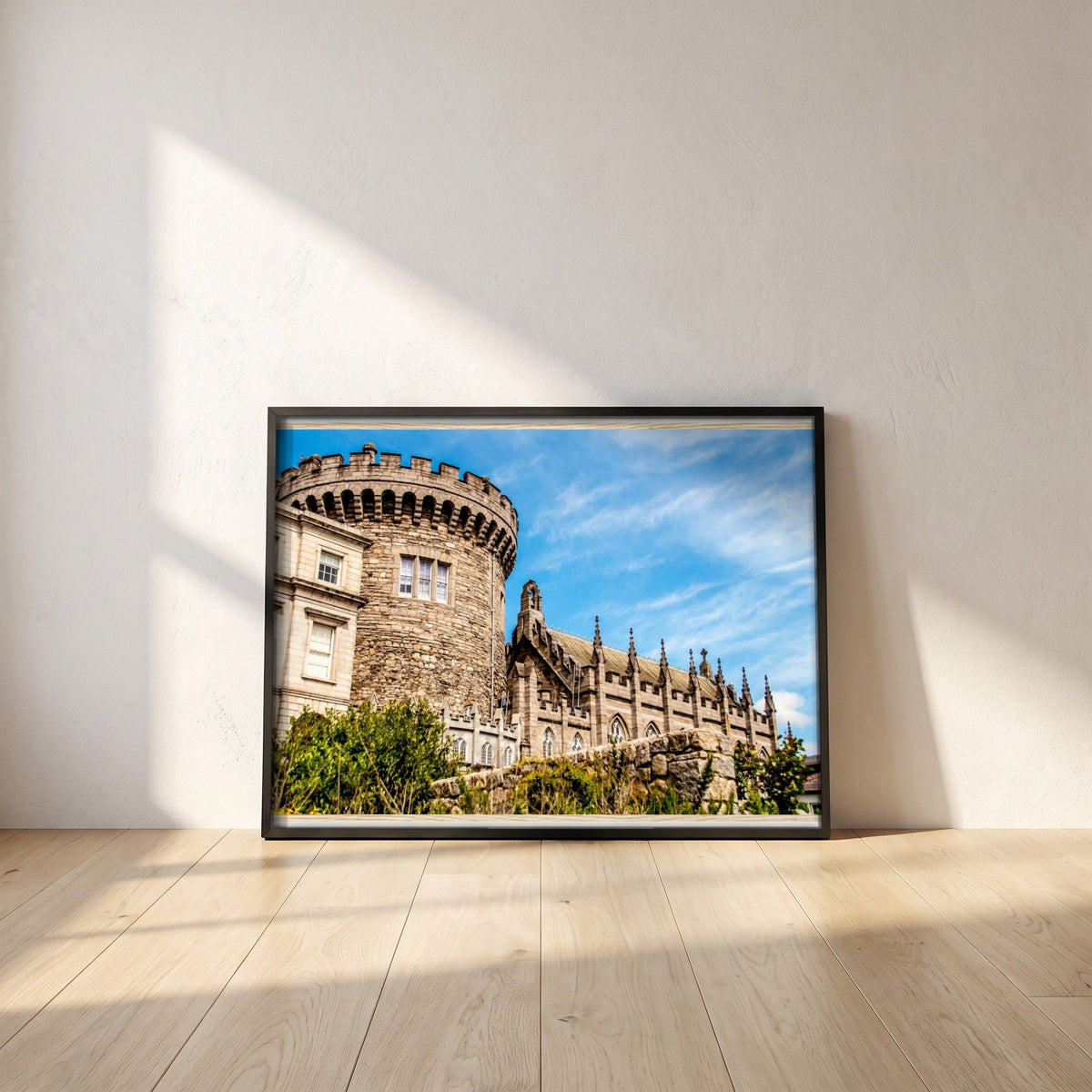 Dublin Castle photographic print in a black frame leaning against a white plaster wall on oak floorboards in morning light