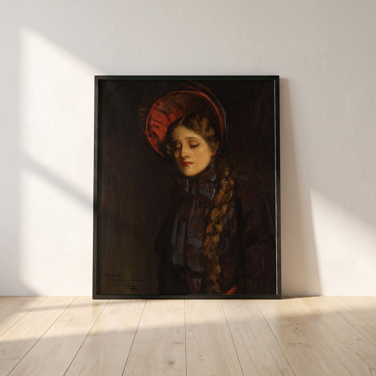 Edna May in The Belle of New York framed print in a black frame leaning against a white plaster wall on oak floorboards in morning light