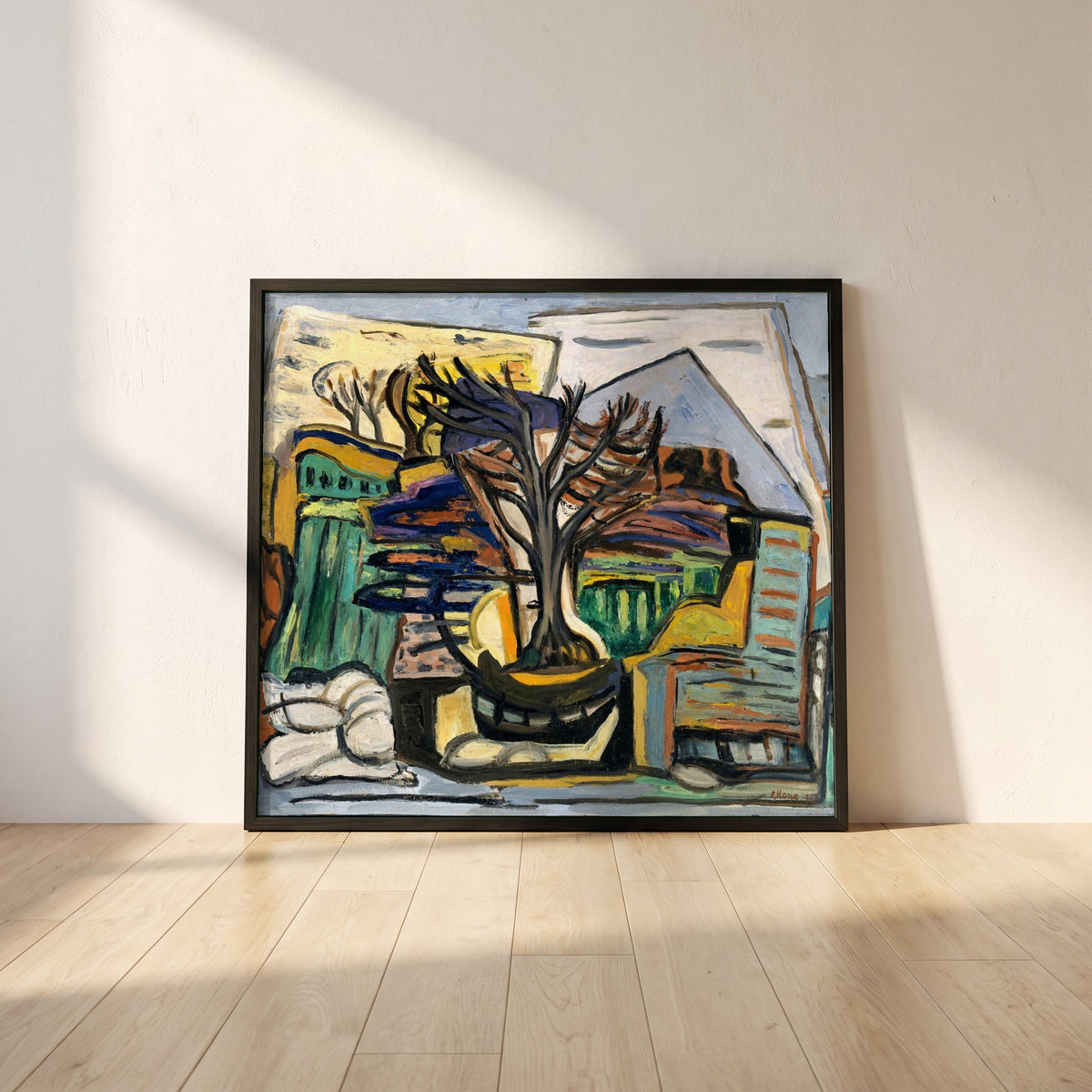 A Landscape with a Tree framed print in a black frame leaning against a white plaster wall on oak floorboards in morning light