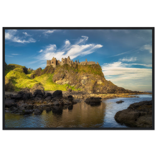 Framed wall art print of Dunluce Castle perched on rugged cliffs in Northern Ireland. The medieval ruins, set against a dramatic coastal backdrop, capture the castle's historic and scenic beauty. Perfect for adding a touch of elegance and history to any room.