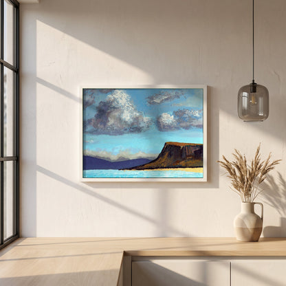 Fair Head from the Sea framed print in a white frame on a plaster wall above an oak worktop in a bright Scandinavian kitchen