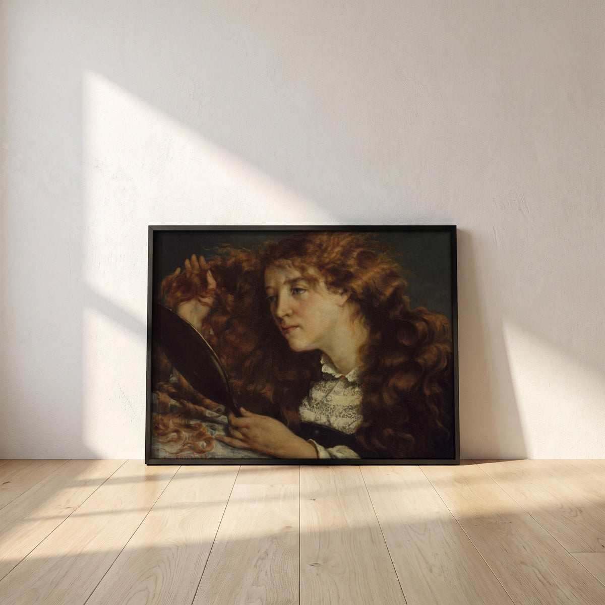 Jo, La Belle Irlandaise by Gustave Courbet framed print in a black frame leaning against a white plaster wall on oak floorboards in morning light