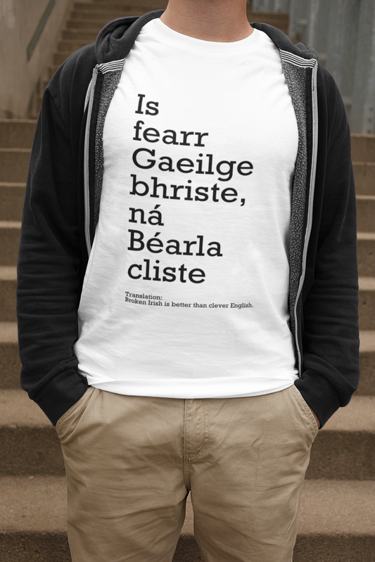 Stylish t-shirt featuring the phrase Is fearr Gaeilge briste ná Béarla cliste in a modern font. The design includes an English translation with black & white text. Ideal for promoting the Irish language.