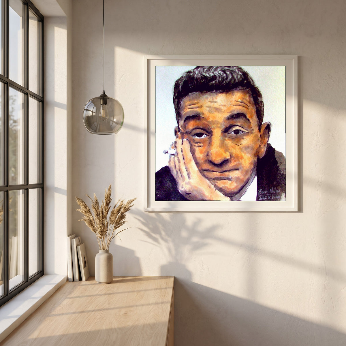 John B. Keane framed print in a white frame on a plaster wall above an oak worktop in a bright Scandinavian kitchen