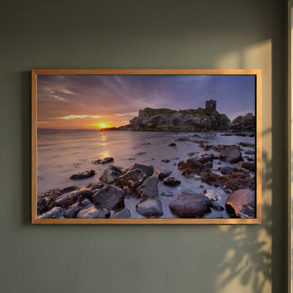 Kinbane Castle Ireland Photography framed print in a natural oak frame on a dark green wall beside a window, dappled plant shadow