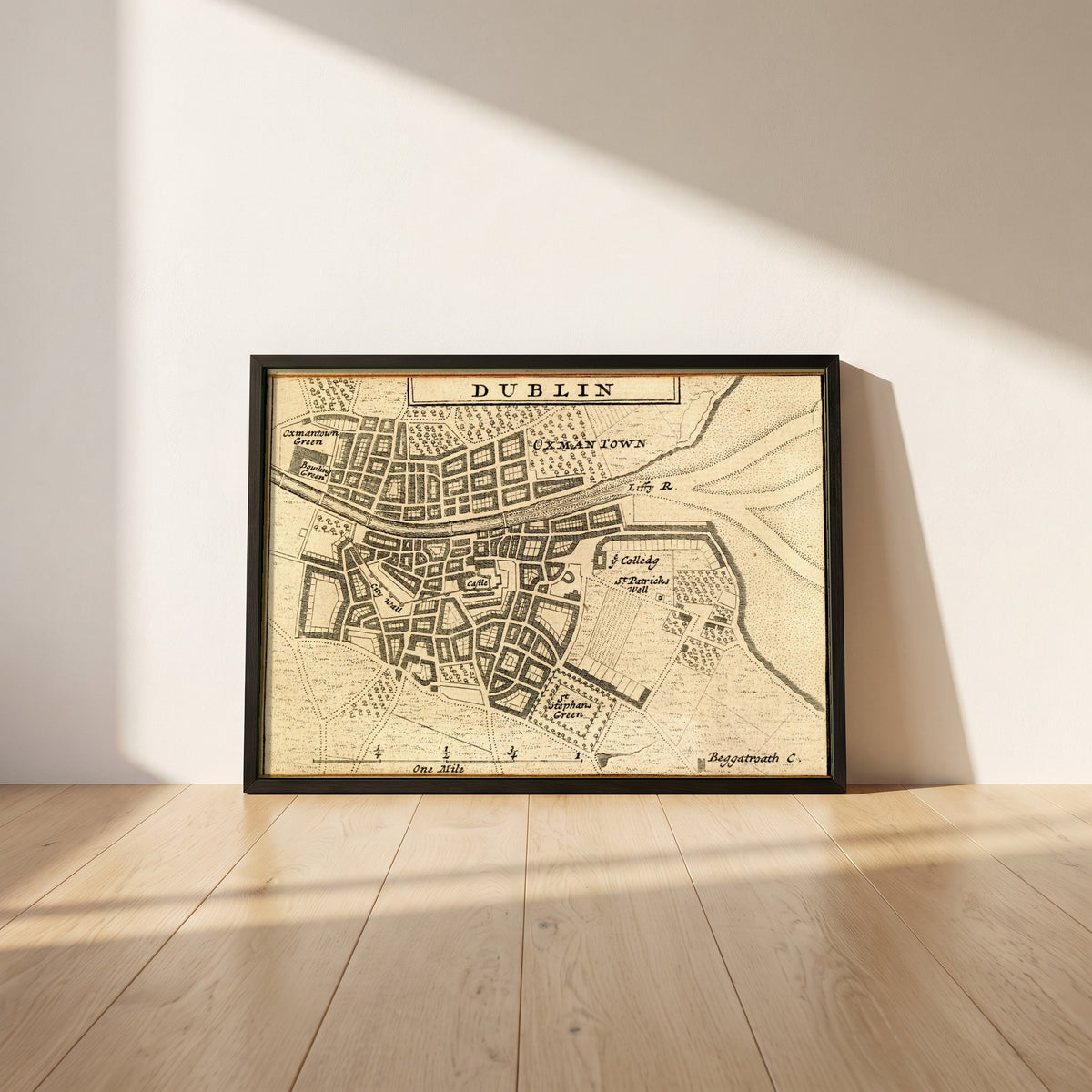 Map of Dublin City in 1714 framed print in a black frame leaning against a white plaster wall on oak floorboards in morning light
