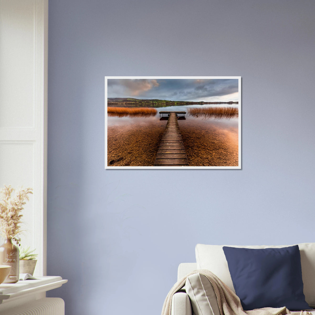 Old Jetty, Lough Derg framed print on a lavender blue wall above a sofa with a navy cushion