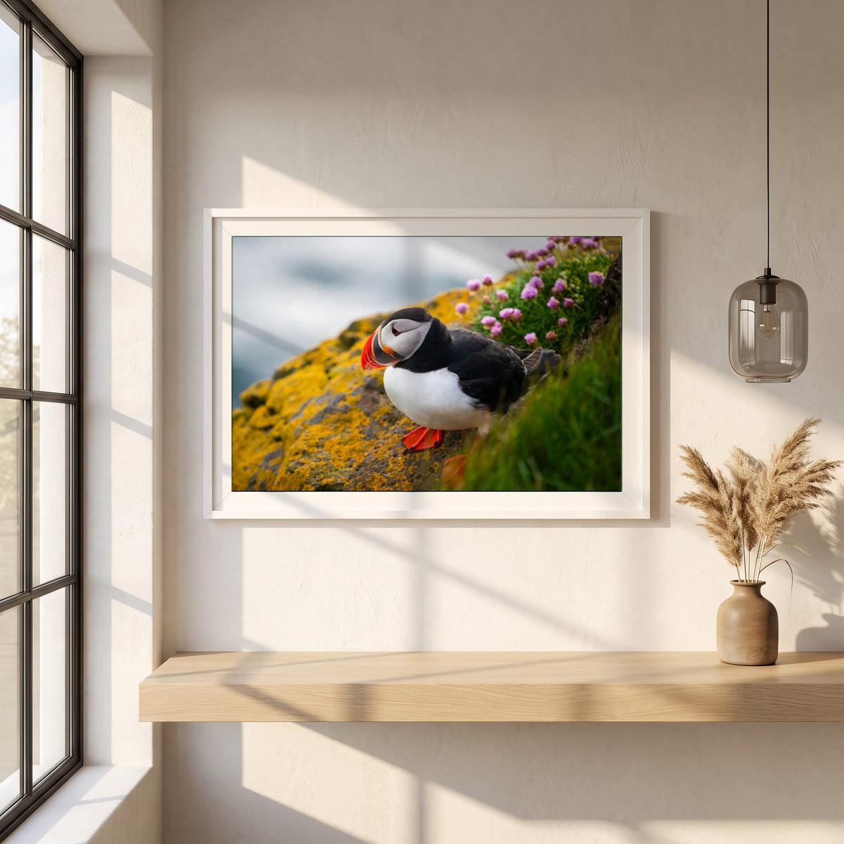 Puffin framed print in a white frame on a plaster wall above an oak worktop in a bright Scandinavian kitchen