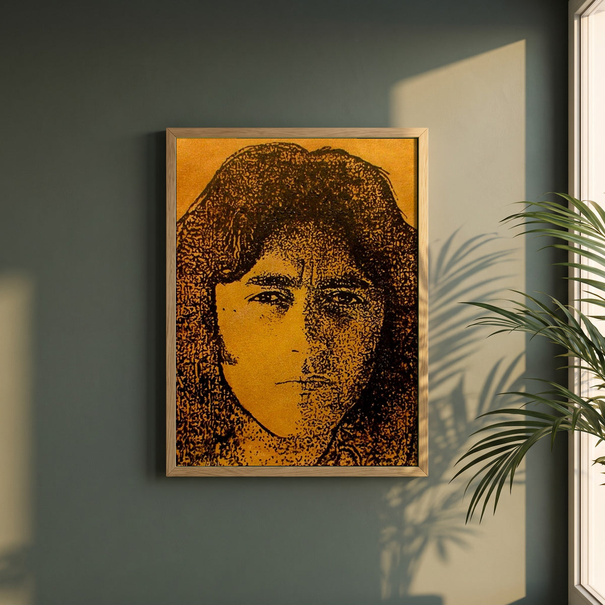 Rory Gallagher framed print in a natural oak frame on a dark green wall beside a window, dappled plant shadow