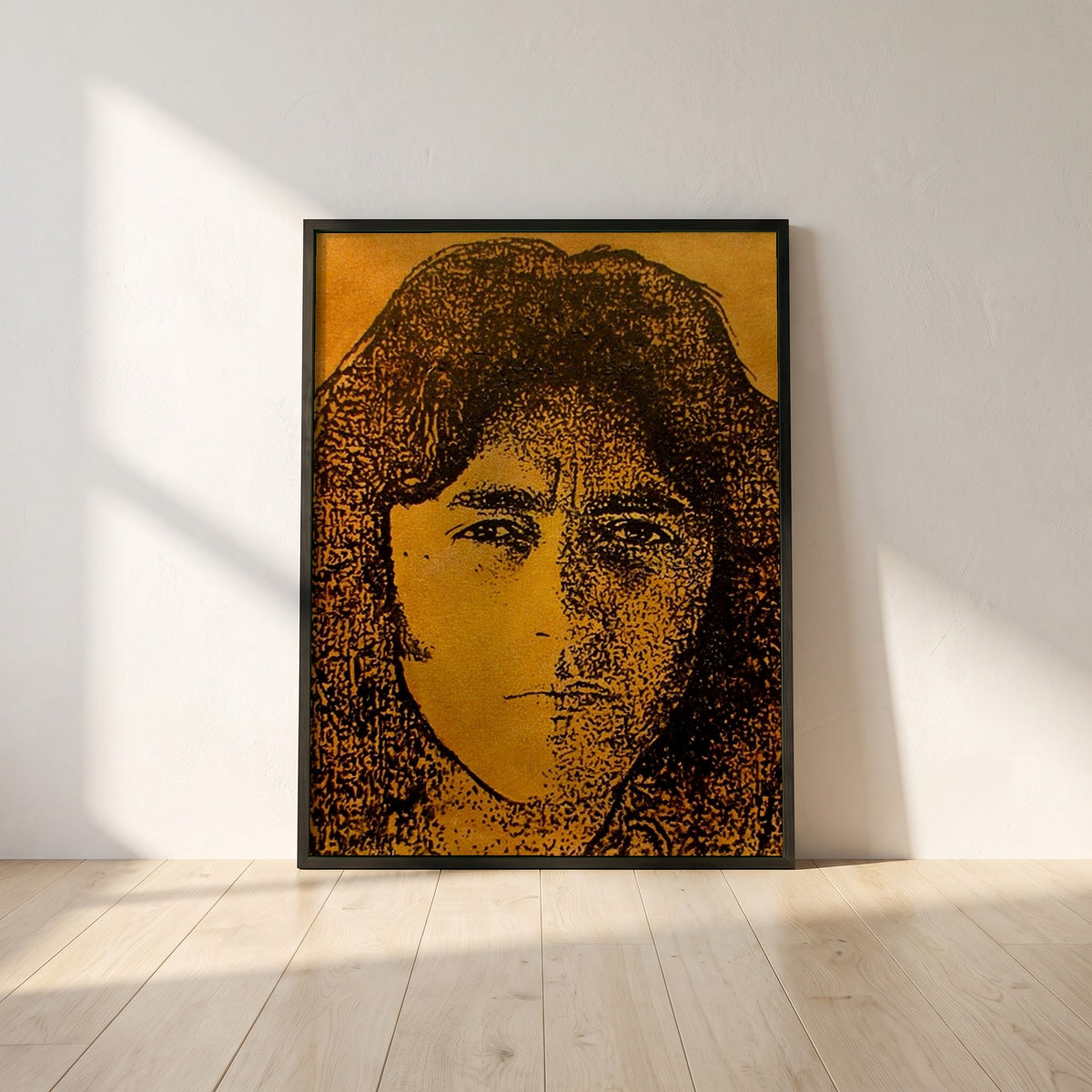 Rory Gallagher framed print in a black frame leaning against a white plaster wall on oak floorboards in morning light