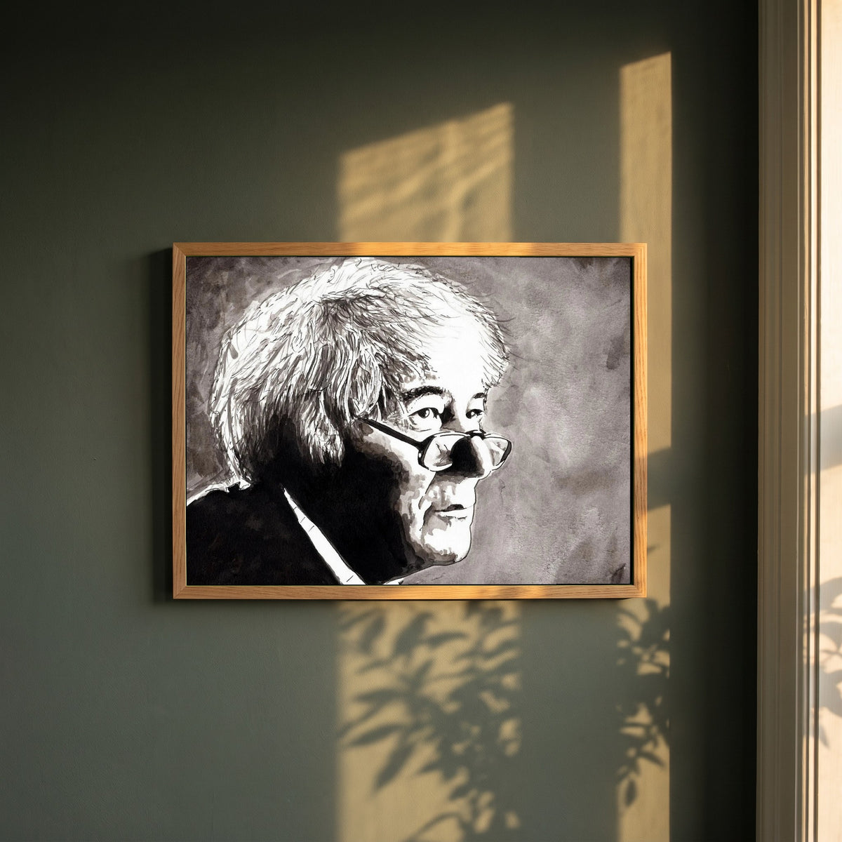 Seamus Heaney framed print in a natural oak frame on a dark green wall beside a window, dappled plant shadow