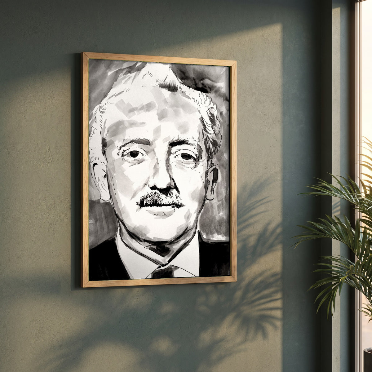 Sean Ó Riada framed print in a natural oak frame on a dark green wall beside a window, dappled plant shadow