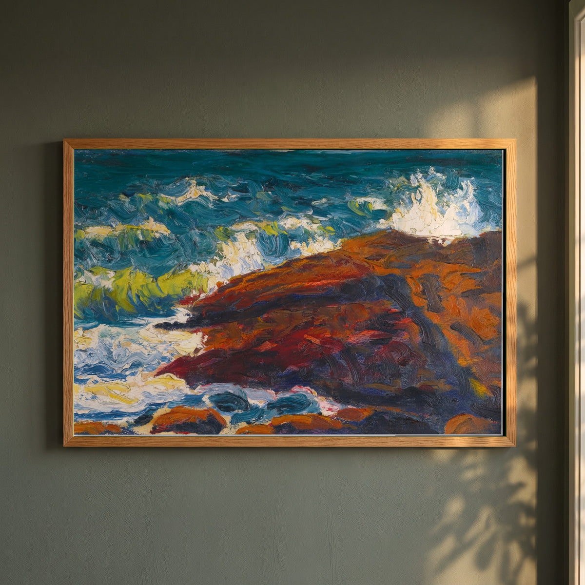 Seascape framed print in a natural oak frame on a dark green wall beside a window, dappled plant shadow