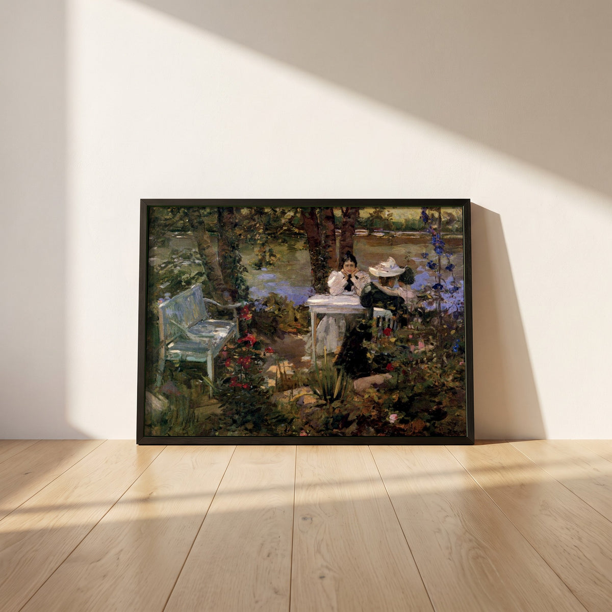 A Garden in France framed print in a black frame leaning against a white plaster wall on oak floorboards in morning light