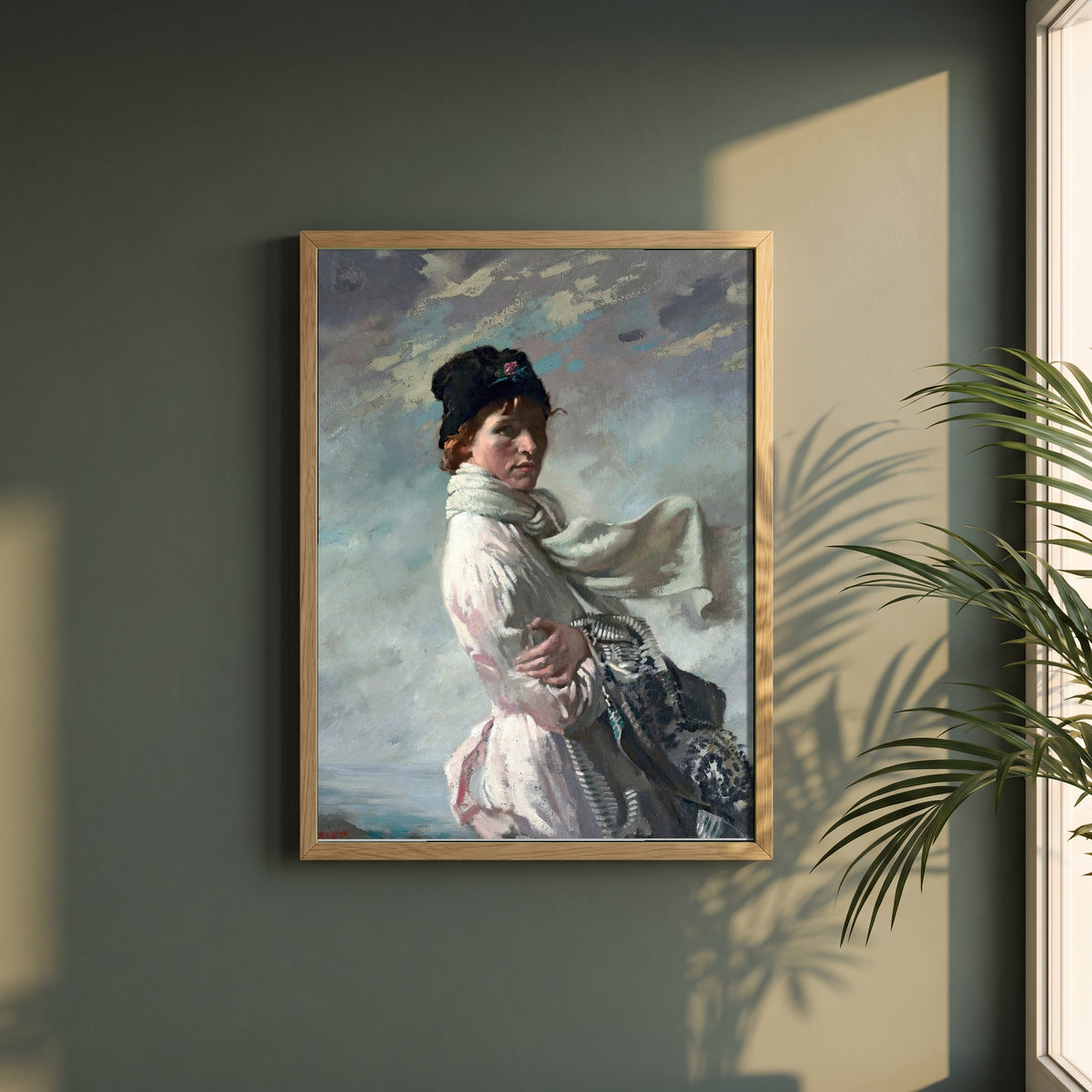 William Orpen framed print in a natural oak frame on a dark green wall beside a window, dappled plant shadow
