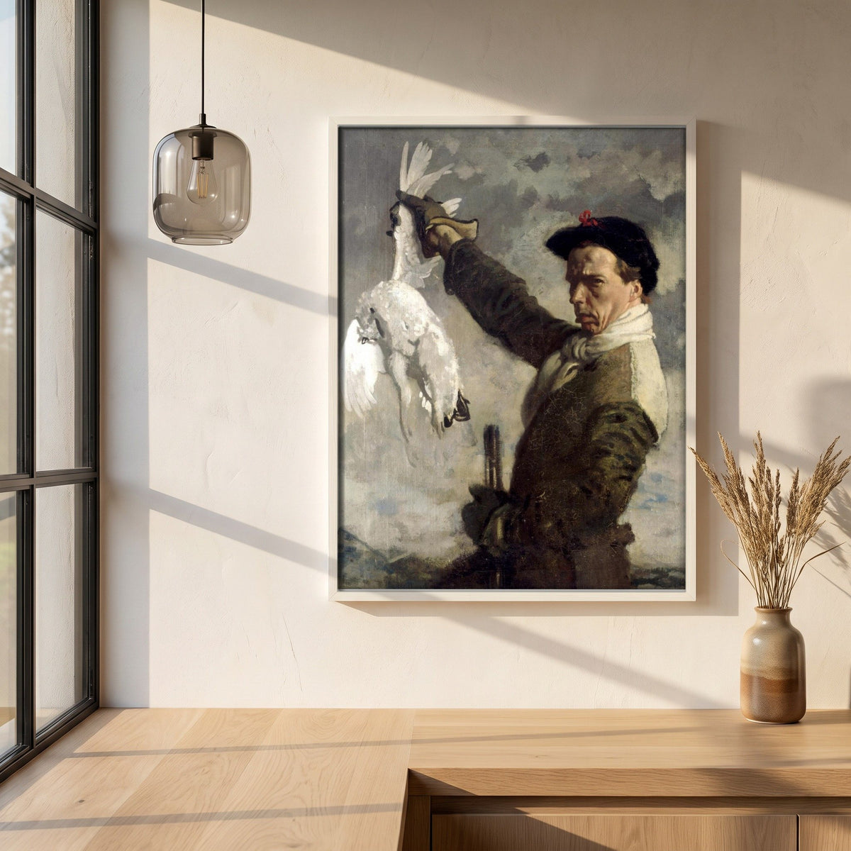 The Dead Ptarmigan (Self-Portrait) by William Orpen framed print in a white frame on a plaster wall above an oak worktop in a bright Scandinavian kitchen
