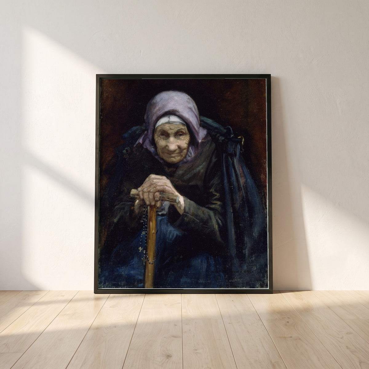 The Fisherman's Mother framed print in a black frame leaning against a white plaster wall on oak floorboards in morning light