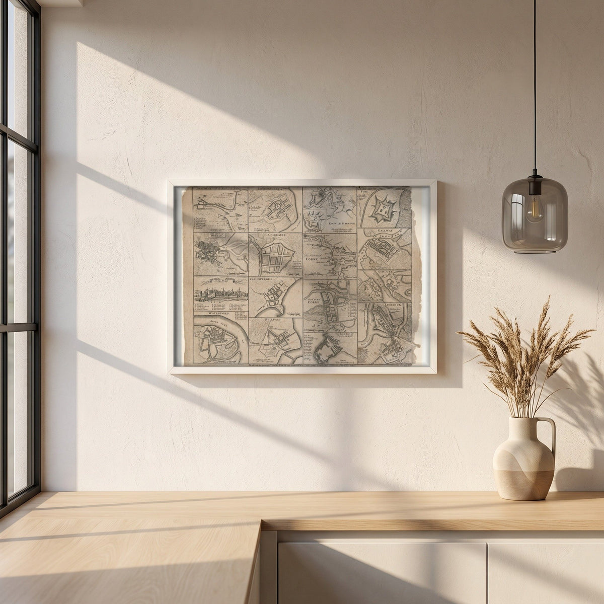Plans of the Towns, Forts and Harbours of Ireland 1748 Map Print framed print in a white frame on a plaster wall above an oak worktop in a bright Scandinavian kitchen