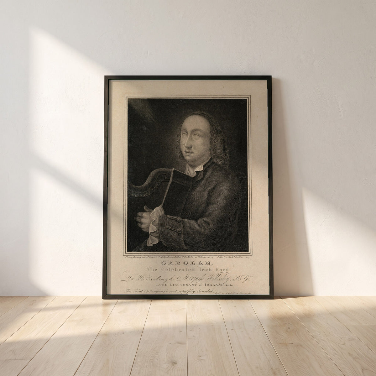 Turlough O’Carolan framed print in a black frame leaning against a white plaster wall on oak floorboards in morning light