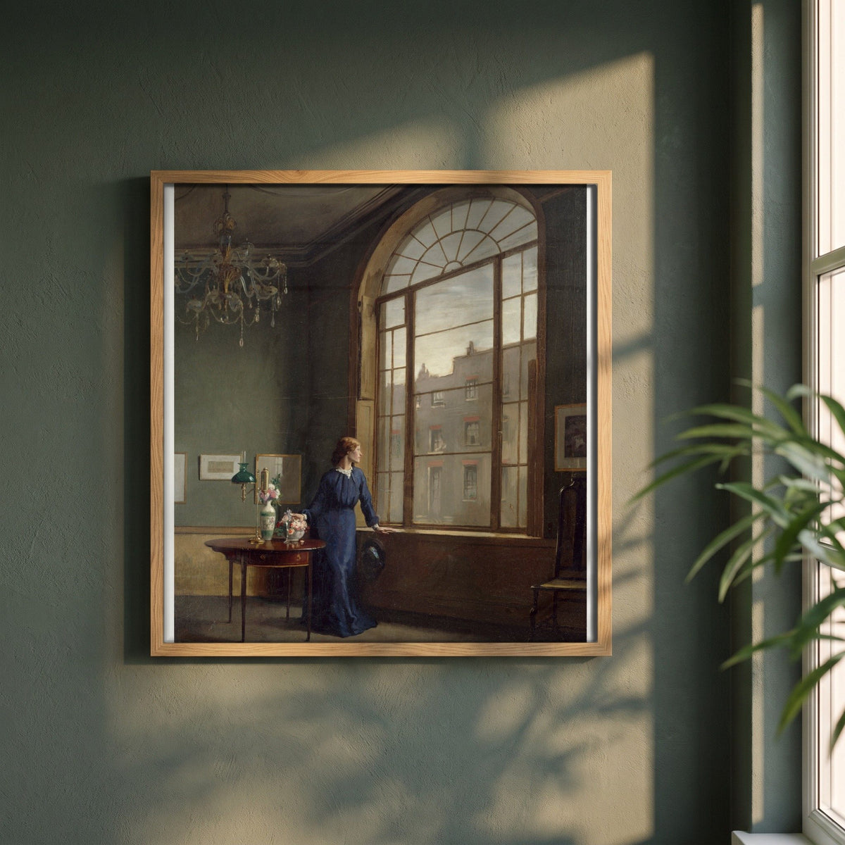 Window in London Street framed print in a natural oak frame on a dark green wall beside a window, dappled plant shadow